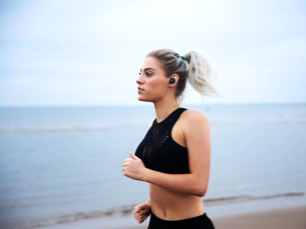 Woman running with the Bose Sport Earbuds